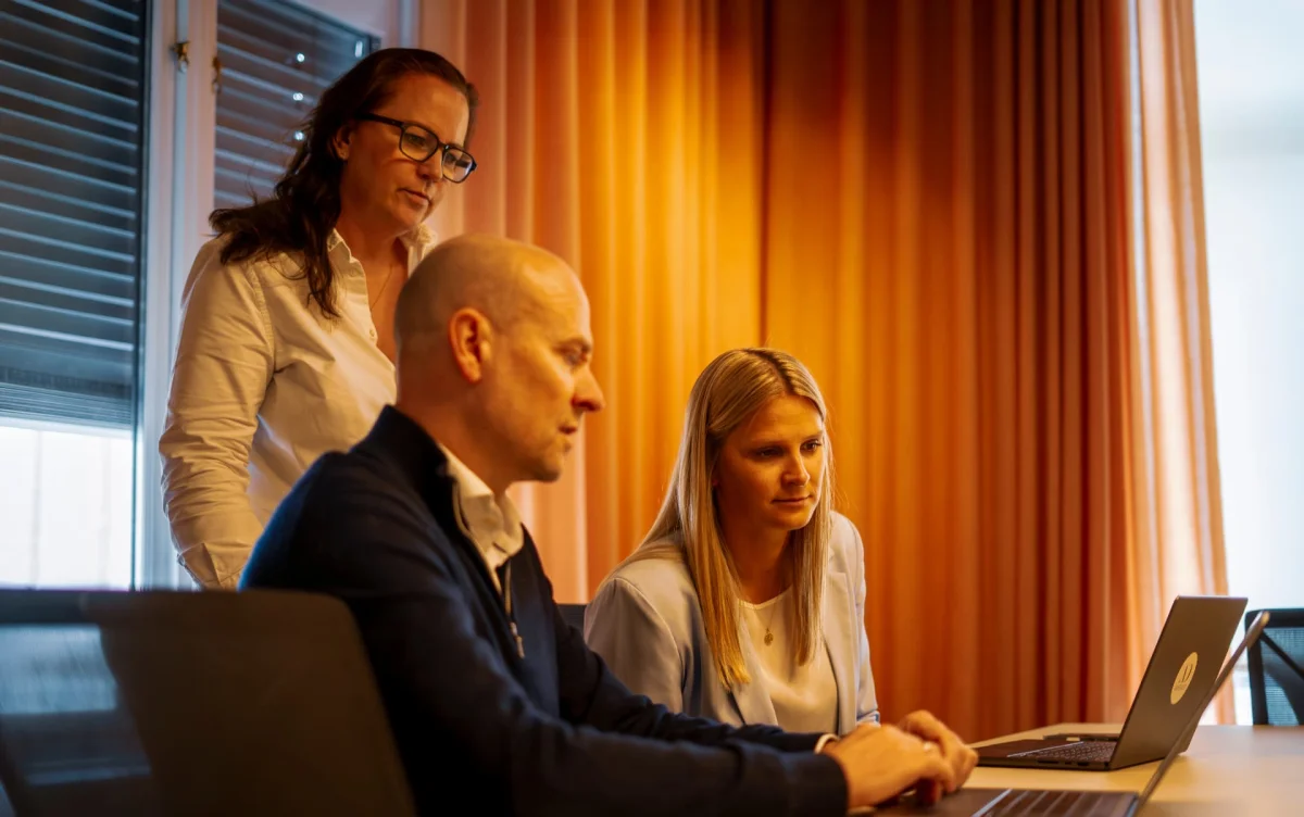 Tre rådgivere fra Amidays i møte foran en laptop